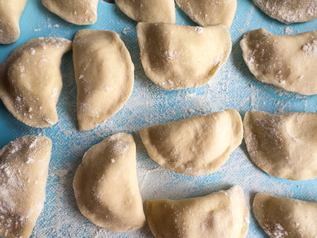 Uncooked ukraine vareniki dumplings tortellini flour home hand made with potatoes and onion. Raw...