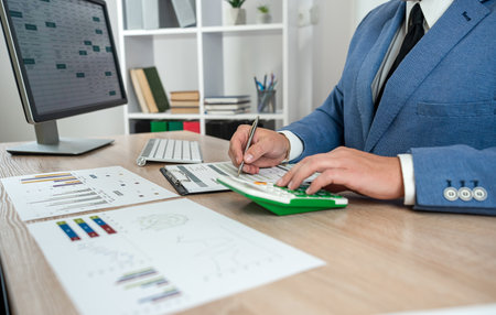 businessman hand working with computer and accounting annual report with business document and income statistics. Financial conceptの写真素材