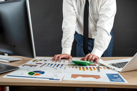 businessman hand working with computer and accounting annual report with business document and income statistics. Financial conceptの写真素材