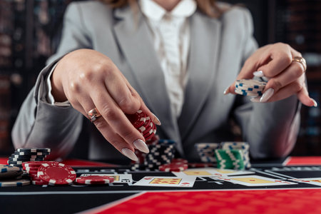 female player plays poker and takes chips to raise the bet. Casino gameの写真素材