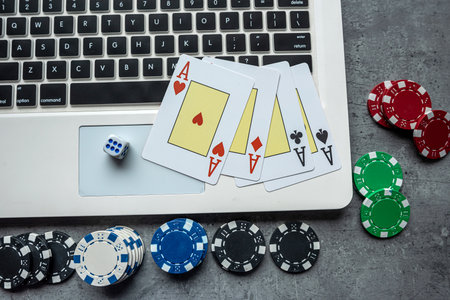 casino chips and playing cards on laptop notebook. Poker game online concept. Gambling