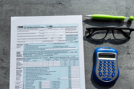 1040 Tax form, pen calculator glasses on table. Time for tax