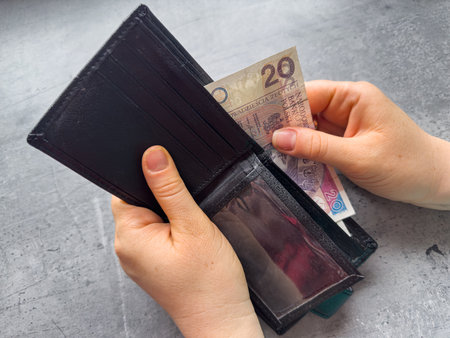woman takes Polish zlotys from wallet close-up. Financial saving conceptの写真素材