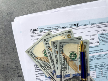 1040 tax forms with us dollar money and pen on office desk. The time to pay taxes, 2024 deadline...