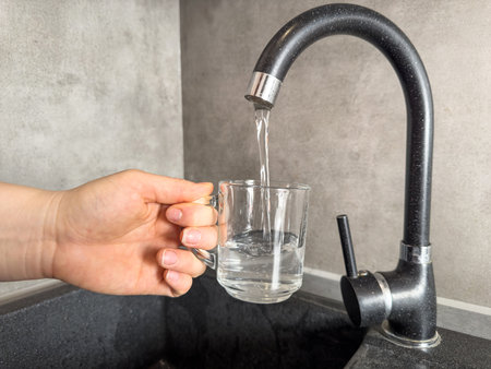 Close up woman filling a glass of water at the kitchen sink. Clean water at homeの写真素材