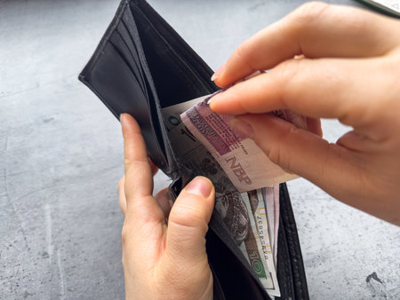 close up woman pulls out polish zloty money from wallet. Polish economy. Woman counts the money