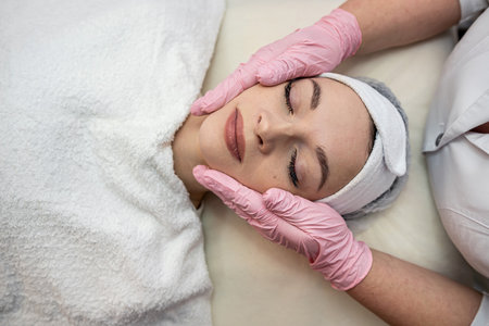 Young woman receive face massage at spa salon. Beauty treatment and body care concept.の写真素材