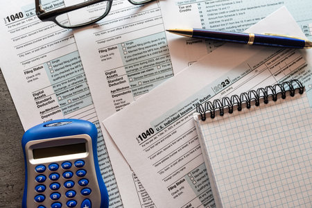 Tax forms, calculator nad pen on office desk paying the tax rate. Business and tax concept