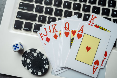 casino chips and playing cards on laptop notebook. Poker game online concept. Gambling