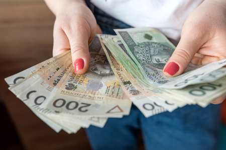 close up woman counts Polish banknotes in her hands, financial concept