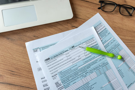 business financial concept 1040 tax form individual income with glasses pen laptop on desk