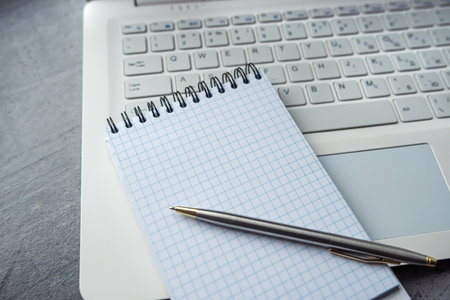 Office desk laptop computer with empty blank notebook pen, workplace at remote work. Flat lay, top viewの写真素材