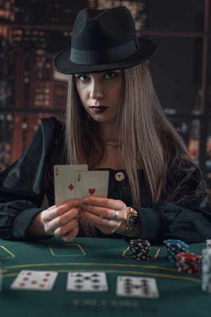Beautiful gorgeous woman playing poker in casino and hold two aces as a winning combination. Luck...