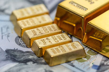 group of gold bar lie on 100 US dollar bills background. Investment and wealth concept