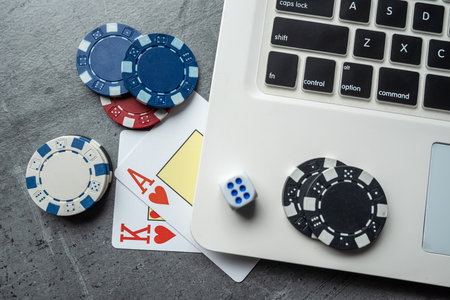 Online game concept poker playing cards and chips with laptop. Gambling