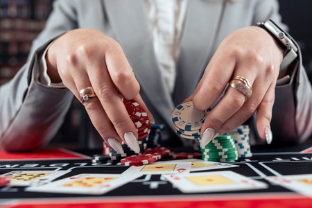 female player takes chips and raises in poker game at casino, throwing chipsの写真素材