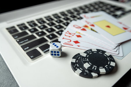 poker playing cards with casino chips on laptop keyboard for online gambling. Top viewの写真素材