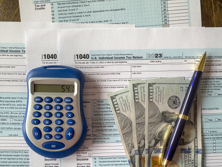 1040 tax form with pen calculator and dollar money. Time for taxの写真素材