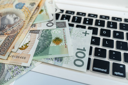 Polish 100 200 zloty polish money on laptop keyboard. Close up, financial concept