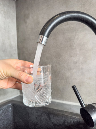 woman hand gaining a glass of tap clean water in kitchen. Healthy life concept