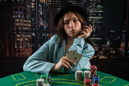 woman's hand takes poker chips and cards from a pile at a round poker table. risky bets in poker....