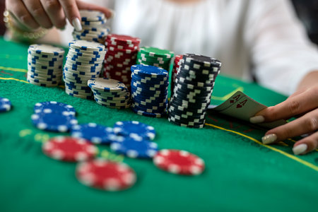 female hands pick up poker chips from a pile at a round poker table. risky bets in poker. woman in...