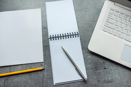 Office desk laptop computer with empty blank notebook pen, workplace at remote work. Flat lay, top...