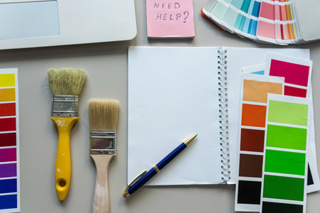 color palette guide for printing with brushes, blank notepad on office desk. Creative workplaceの写真素材