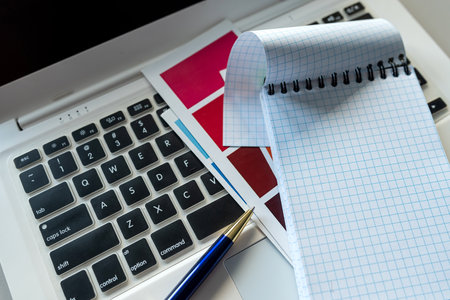 Desktop with a laptop and Notepad for notes color catalog, creative workplaceの写真素材