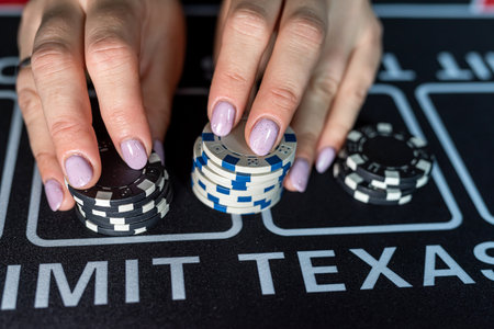 female poker player takes chips and raises bet. Playing poker in a casino. A chance to winの写真素材