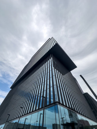 Exterior of a modern office building. Glass building skyscrapers over grey cloudy skyの写真素材