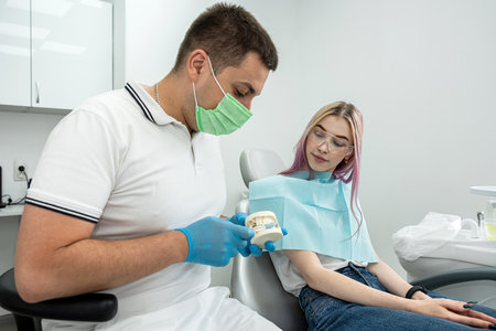 examination of a dentist treating a female patient who came to him with complaints. A woman has a scheduled dental examination at the dentist.の写真素材