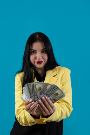 Happy businesswoman in yellow suit counting cash dollars isolated on blue. Money payment or big...