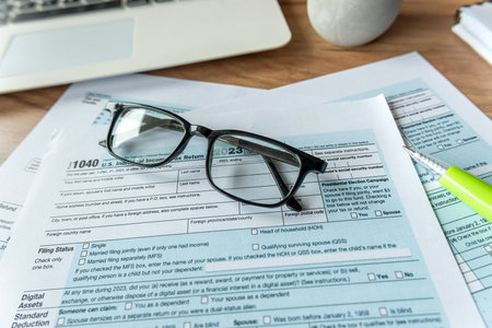business financial concept 1040 tax form individual income with glasses pen laptop on desk