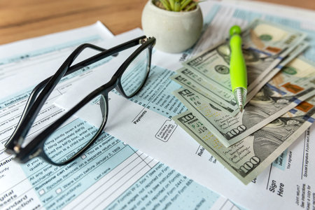 accounting paperwork individual tax form 1040 glasses dollar and pen on desk. Deadline conceptの写真素材