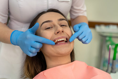 Doctor use dental tools for to check teeth and gums, caries prevention for her female patient. Oral...