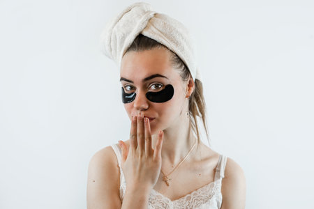 Pretty young woman with hydrogel eye patches isolated on white. Concept of spa facial treatmentの写真素材
