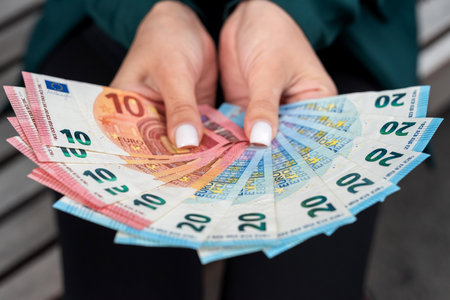 Woman holding 10 20 euro money bills. Concept of finance or saving paymentの写真素材