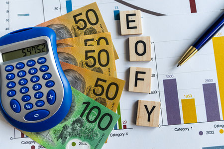 Statistic finance document with pen calculator aud Australia dollar banknotes and EOFY on wooden cubesの写真素材