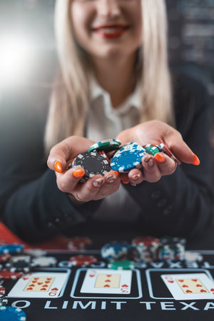 Woman player hold poker chips on the table with card in a casino. Jackpotの写真素材