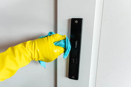 Woman wear gloves with rag cleaning door handle, house sanitary workの写真素材