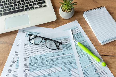 business financial concept 1040 tax form individual income with glasses pen laptop on deskの写真素材