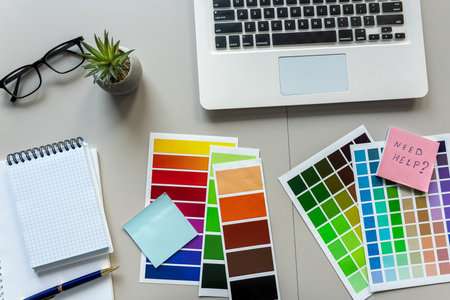 Desktop with a laptop and Notepad for notes color catalog, creative workplaceの写真素材