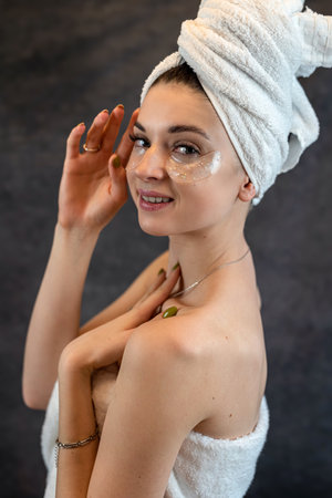 young cute girl in white towel clean skin with black silicone patches isolated on black background....
