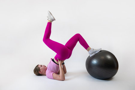 Athletic woman make workout on gym ball on white background. Sport conceptの写真素材