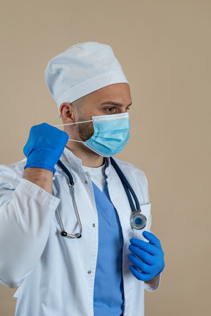 The doctor takes off his mask after a hard day's work isolated. Healthcareの写真素材