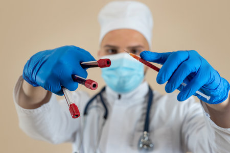 Doctor wear white uniform gloves and mask holding medical injection syringe isolated. Medical staffの写真素材