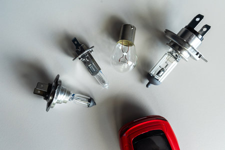 red toy car with different car headlight h1 h4 h7 for repair. Automotive front light bulb. Car repair conceptの写真素材