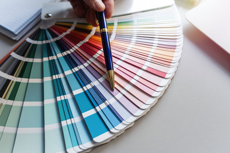 Creative designer shows to the selected color in the palette. Color paint swatchesの写真素材