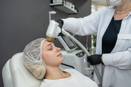 cosmetologist making laser epilation on the woman face while visiting beauty center on salon. Health care conceptの写真素材